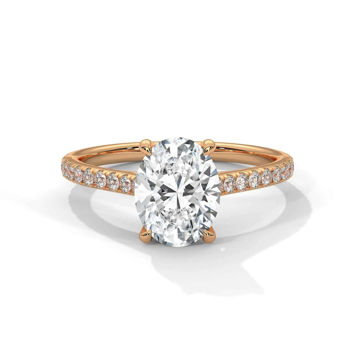 Oval center diamond ring in yellow gold with pavé band and four-prong setting