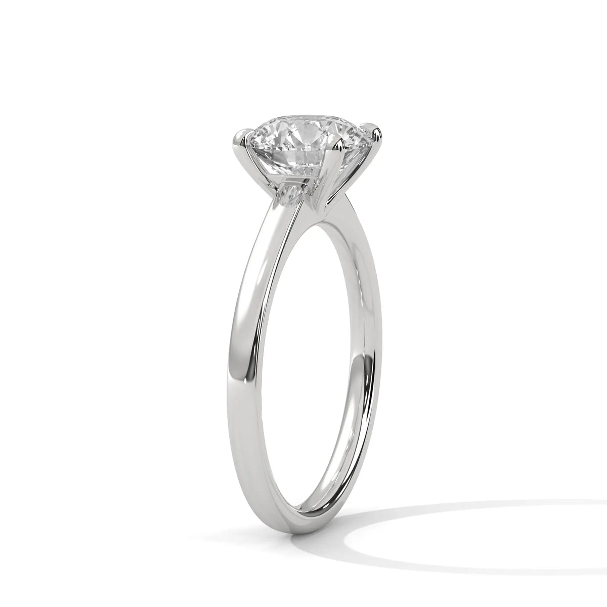 White gold round diamond solitaire ring with four-prong setting, side view