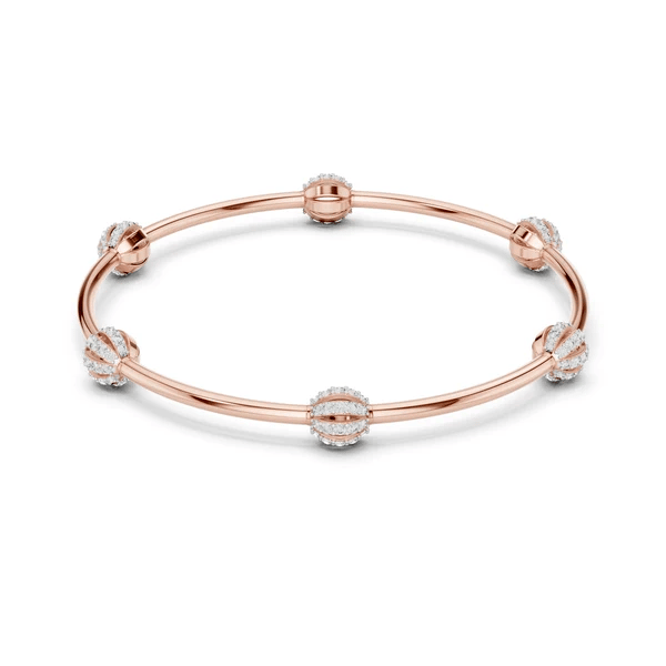 Rose-gold tone bangle bracelet with crystal pavé links and round central charm