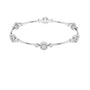 White gold diamond bangle with round clusters spaced along a slim bracelet cuff.