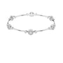 White gold diamond bangle with round clusters spaced along a slim bracelet cuff.