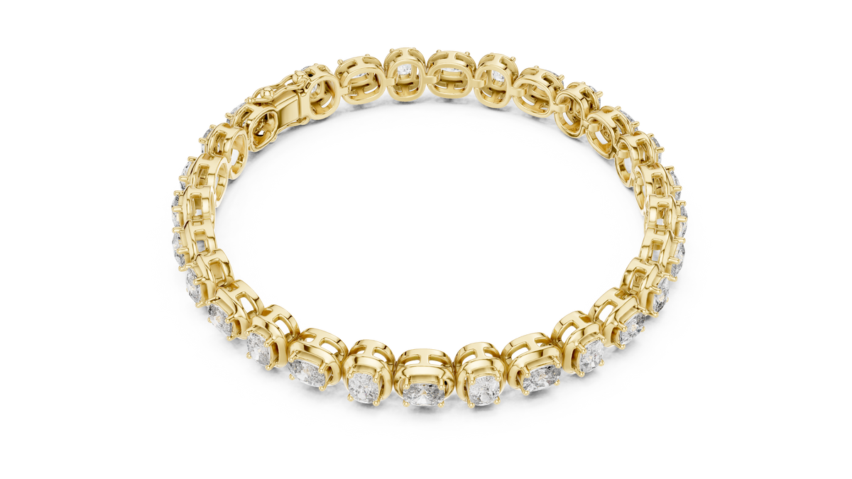 Yellow gold cushion-cut diamond tennis bracelet with small sparkle stones along the band