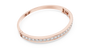 Rose gold diamond bangle with round channel-set stones, angled view.