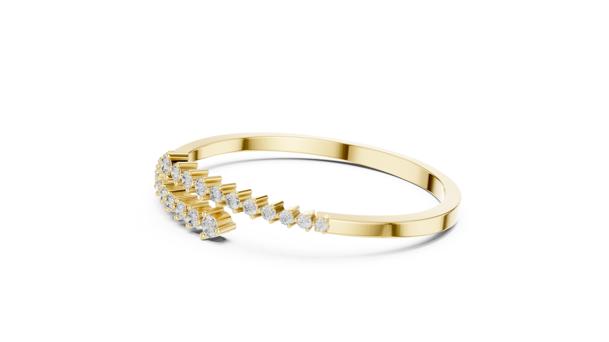 Yellow gold bypass bangle with round diamond pavé accents, angled view.