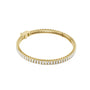 Gold-tone tennis bracelet with baguette-cut diamond stations along a hinged frame