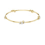 Yellow gold diamond bangle with round center stone and side diamond clusters