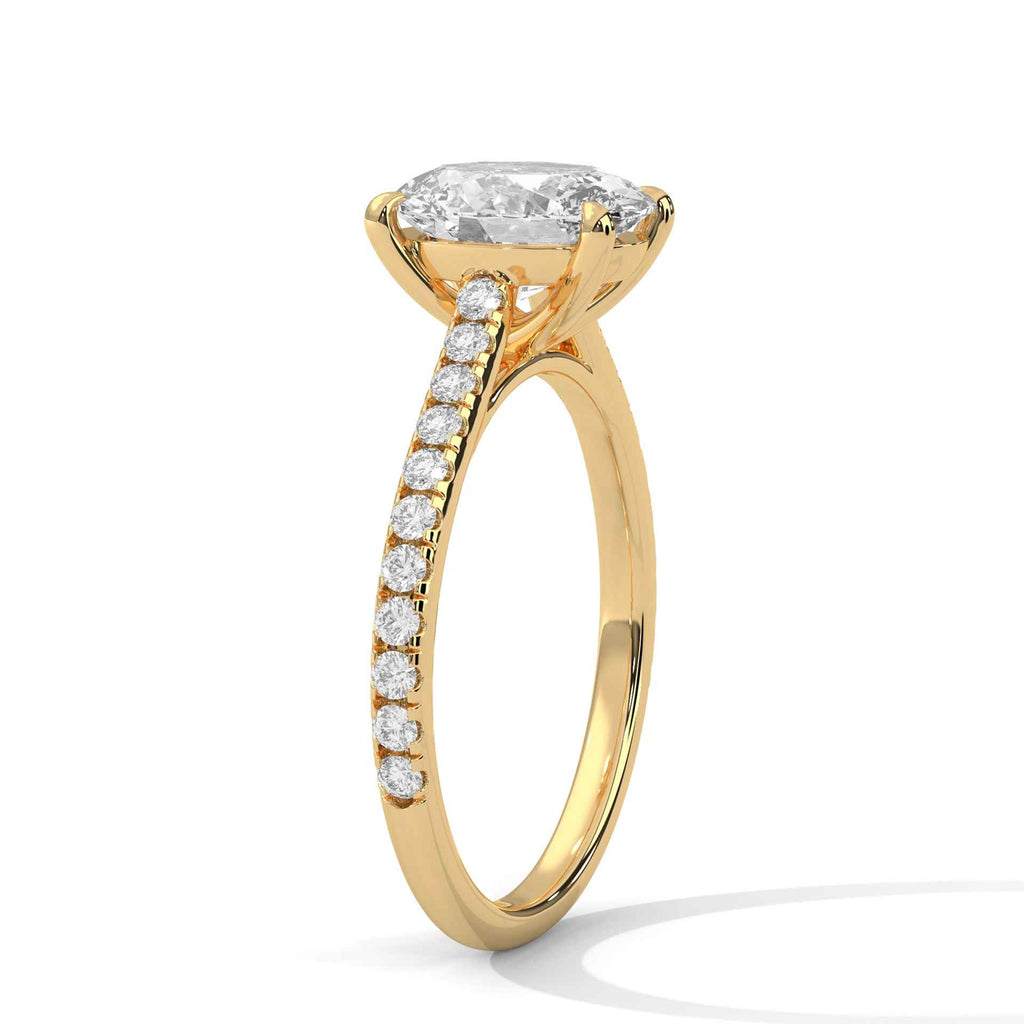 Oval engagement ring in yellow gold with pavé diamond band and cathedral-set oval center stone
