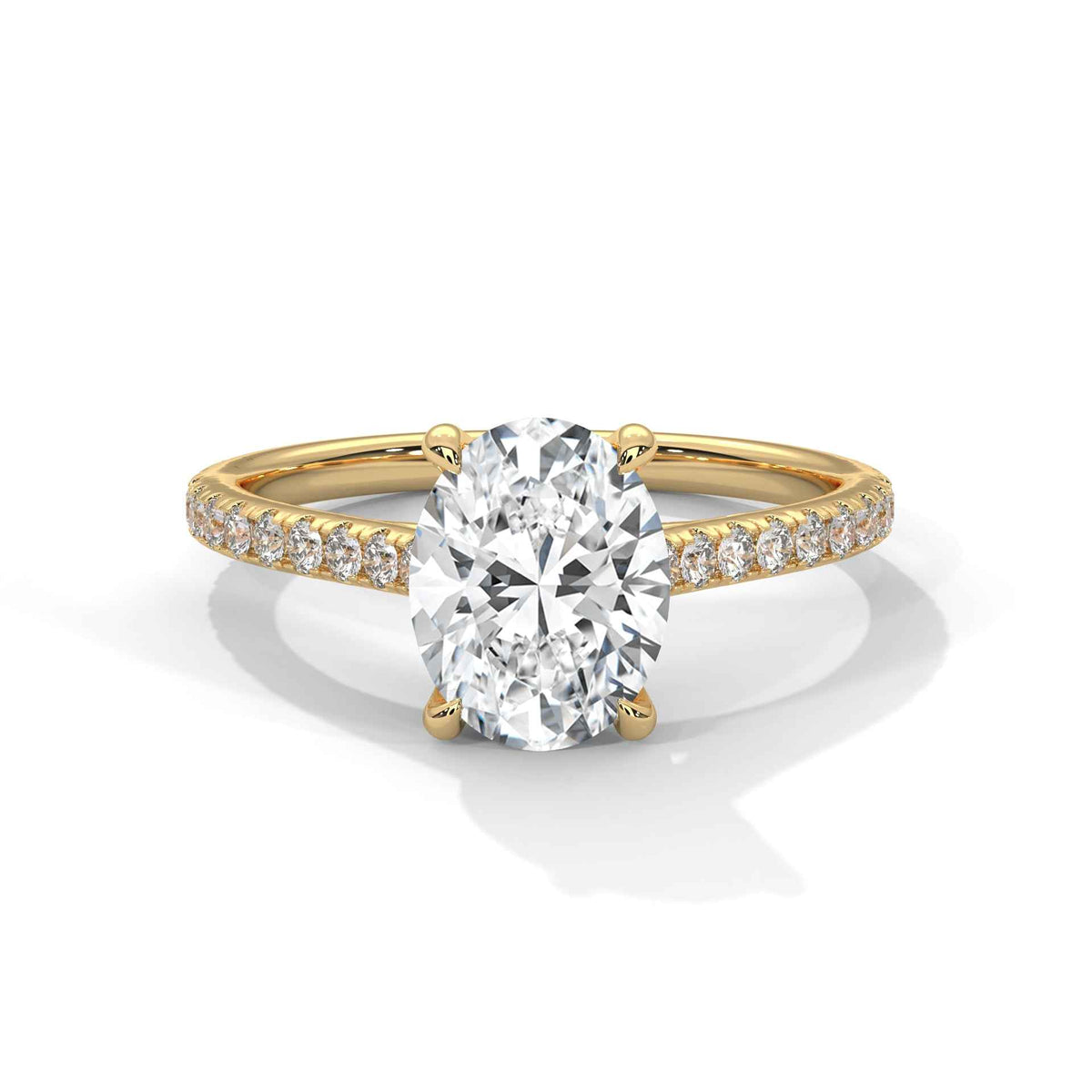Oval center diamond ring in yellow gold with pavé band and four-prong setting