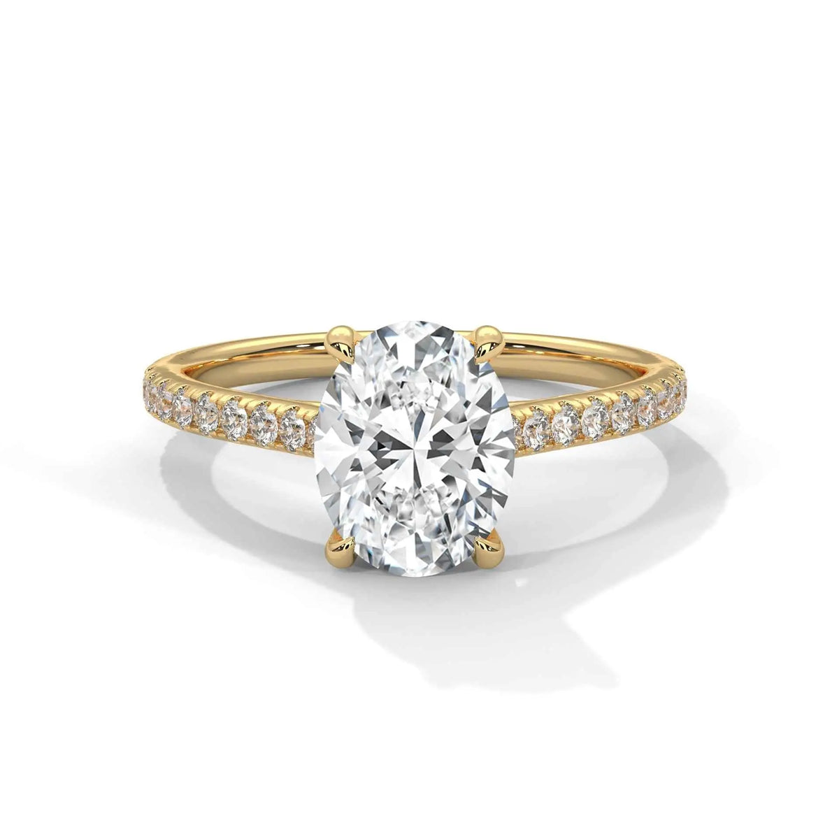 Oval center diamond ring in yellow gold with pavé band and four-prong setting