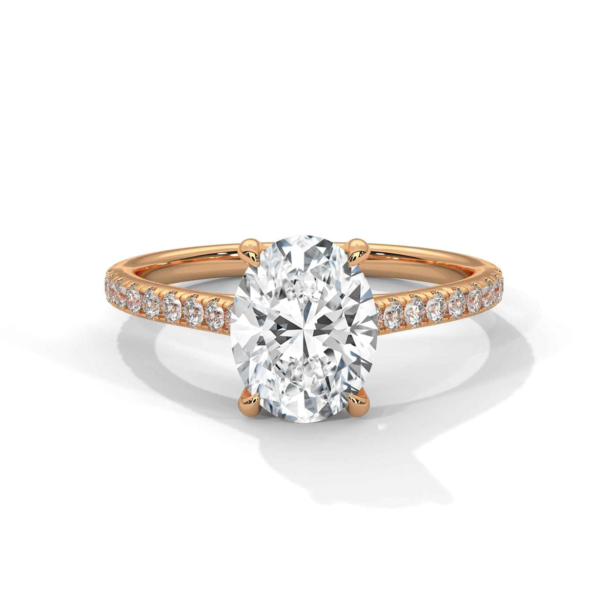 Oval center diamond ring in yellow gold with pavé band and four-prong setting