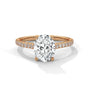 Oval center diamond ring in yellow gold with pavé band and four-prong setting