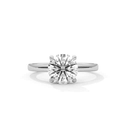 Round diamond solitaire ring with four-prong setting on white metal band