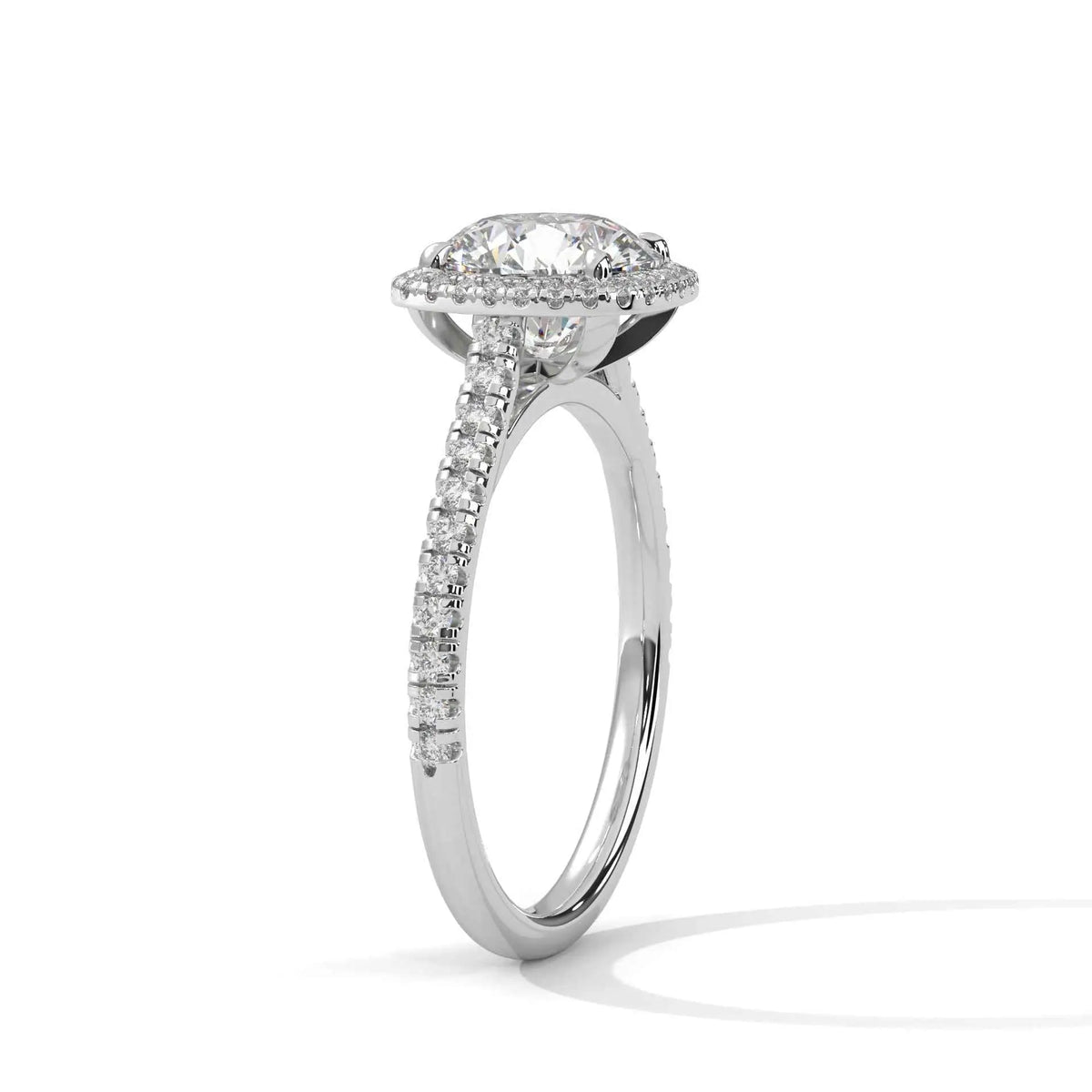 Cushion halo diamond ring side view in platinum with prong-set cushion center and pavé