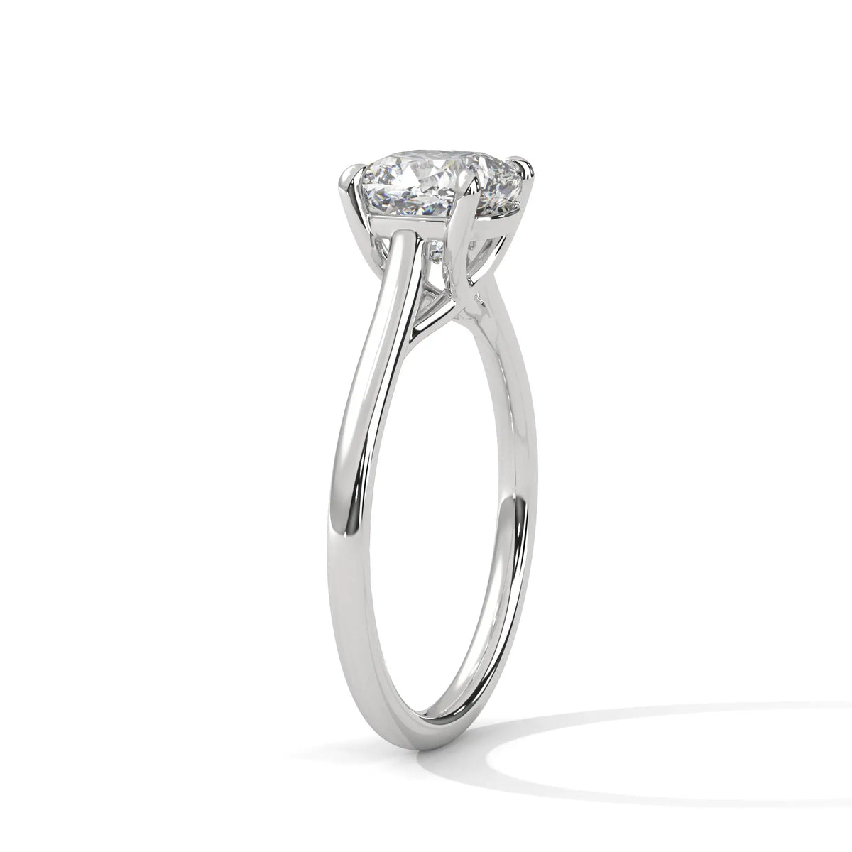 Cushion-cut solitaire engagement ring in platinum with cathedral-style prongs