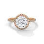 Round halo engagement ring with prong-set center stone, warm yellow gold tone and pavé band