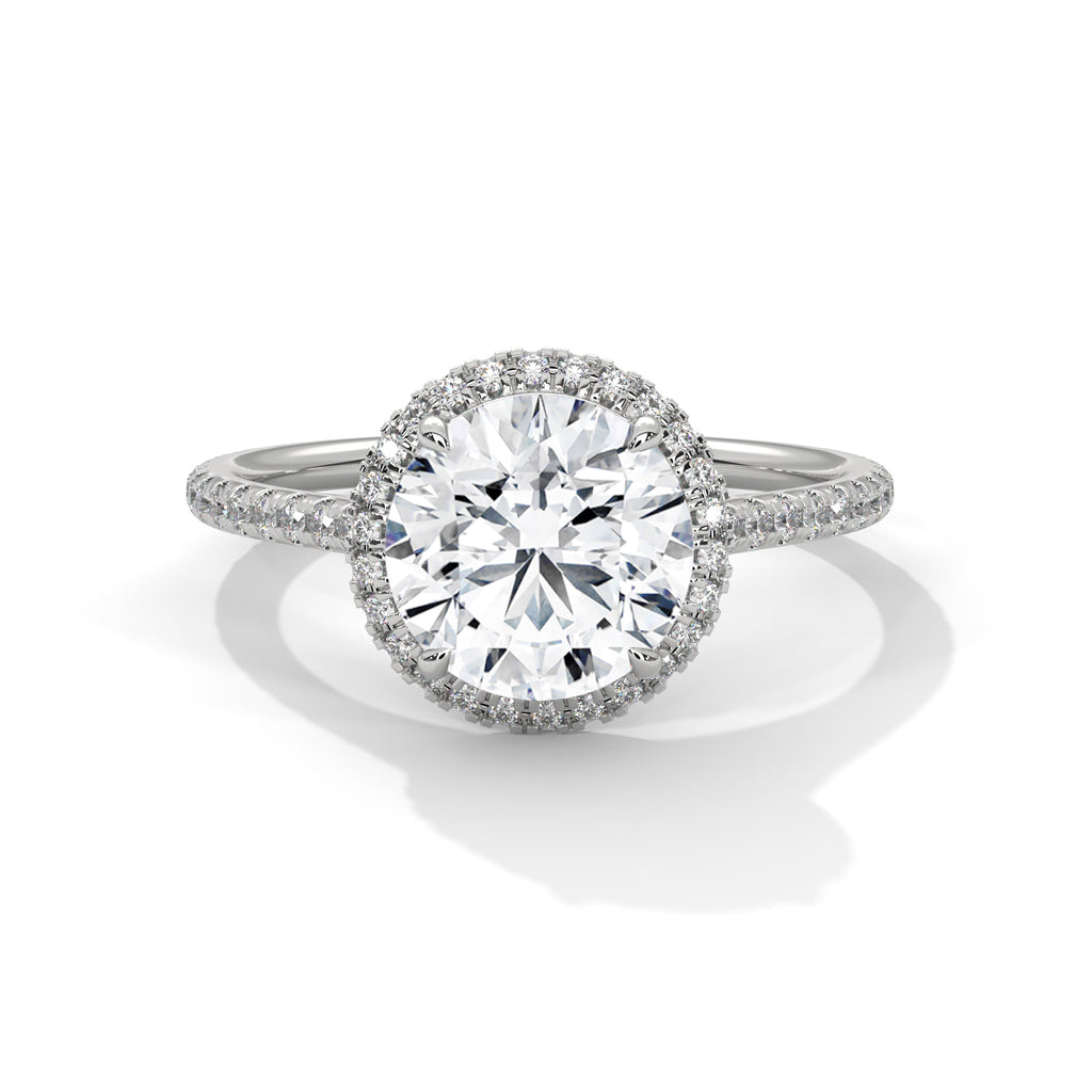 Round halo engagement ring with prong-set center stone, white metal and pavé diamond halo