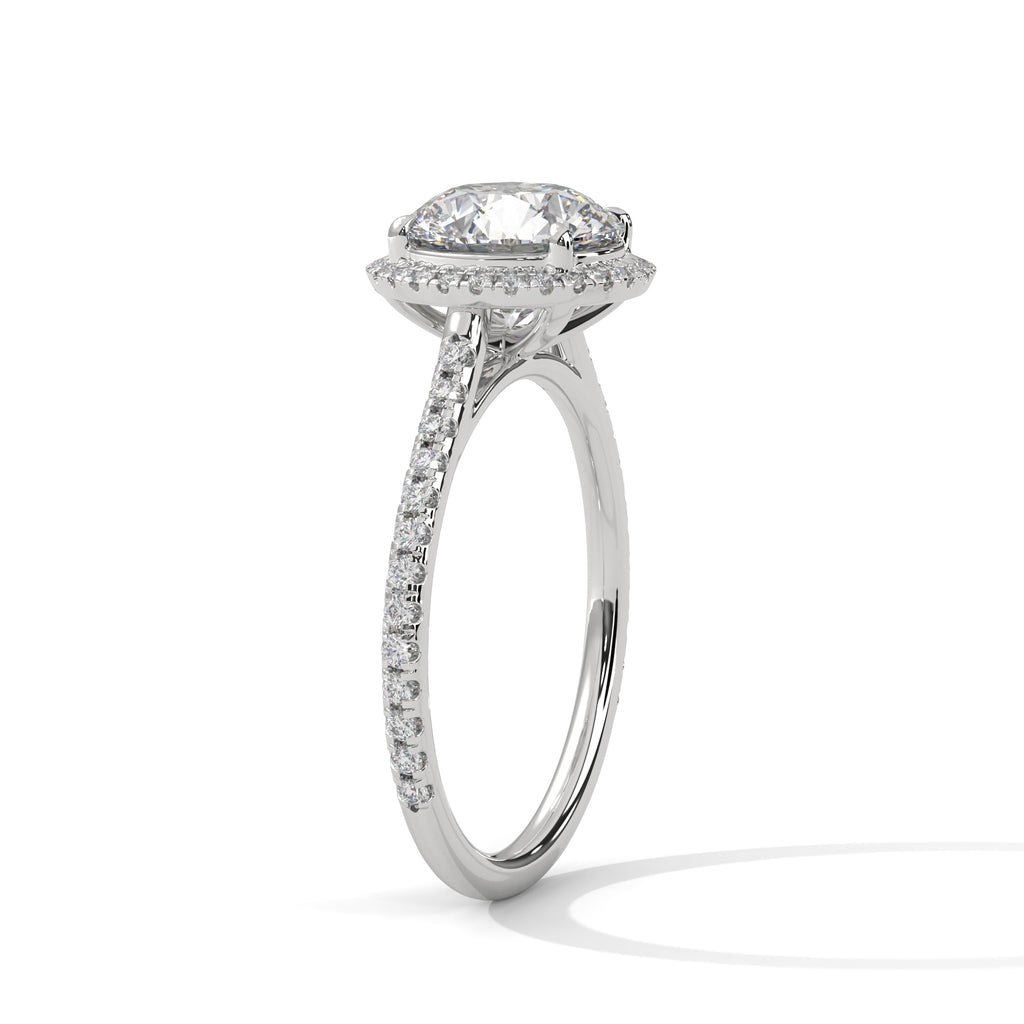 Round halo engagement ring with prong-set center stone, bright white metal and pavé band