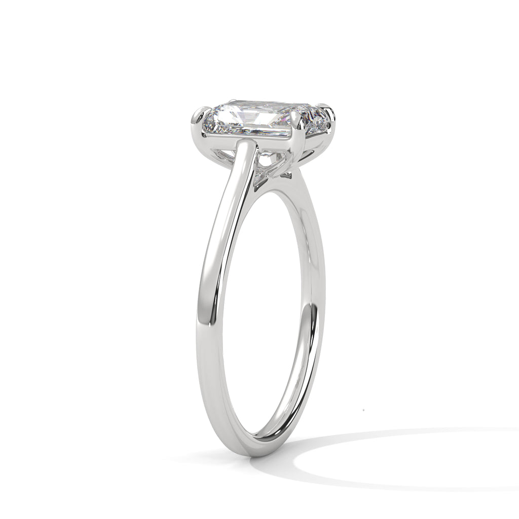 White gold solitaire engagement ring with emerald-cut center stone and trellis-style prongs