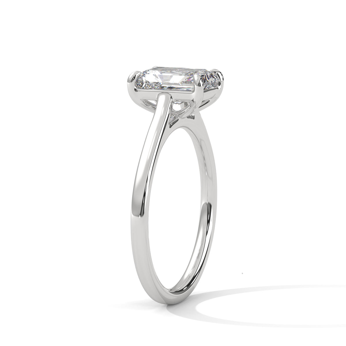 White gold solitaire engagement ring with emerald-cut center stone and trellis-style prongs