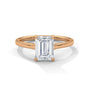 Rose gold solitaire engagement ring with emerald-cut center stone in four-prong trellis setting